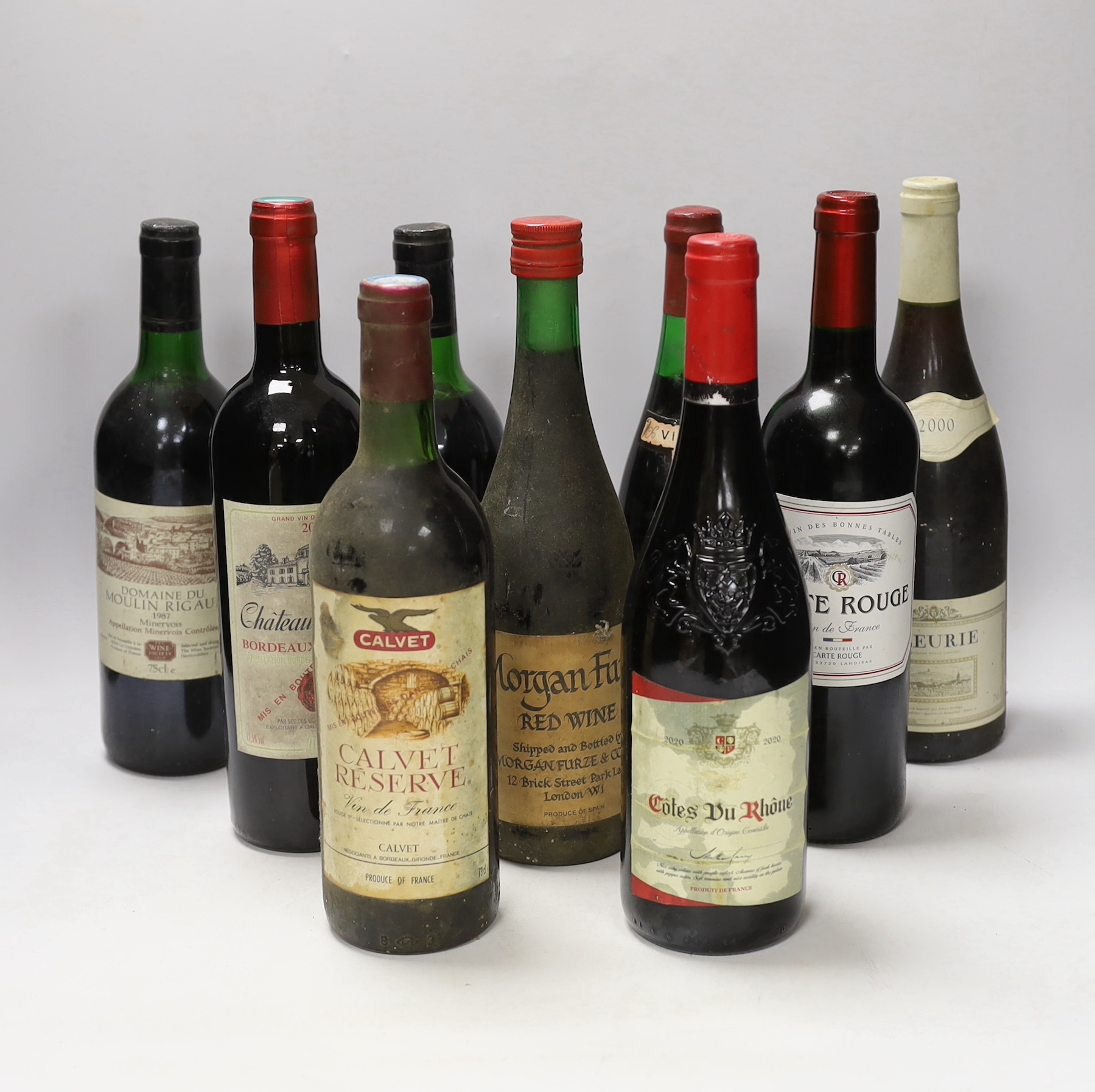Nine bottles of red wines: a bottle of Tambour Vintage Cote du Rhône 1976, two bottles of 1987 Domaine Du Moulin Riguad, a bottle of Chateau Recougne Bordeaux Superieur 2000, a bottle Fleurie 2000 and four other red wine